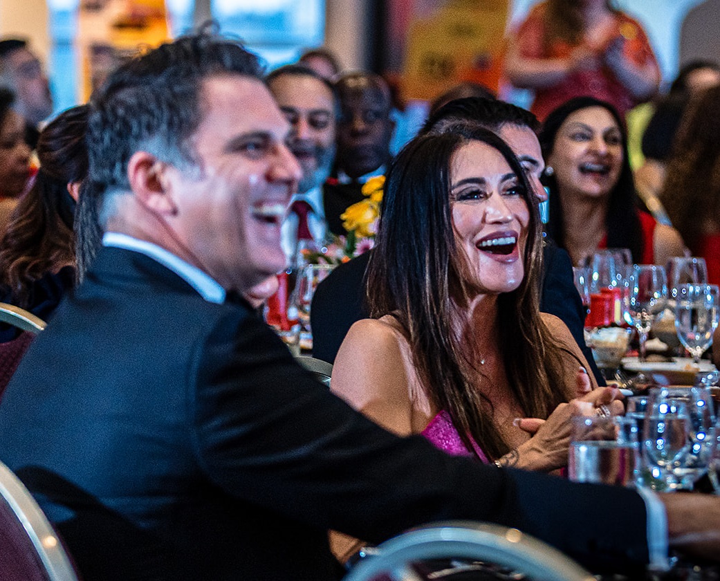 Man and woman laughing at their table. 